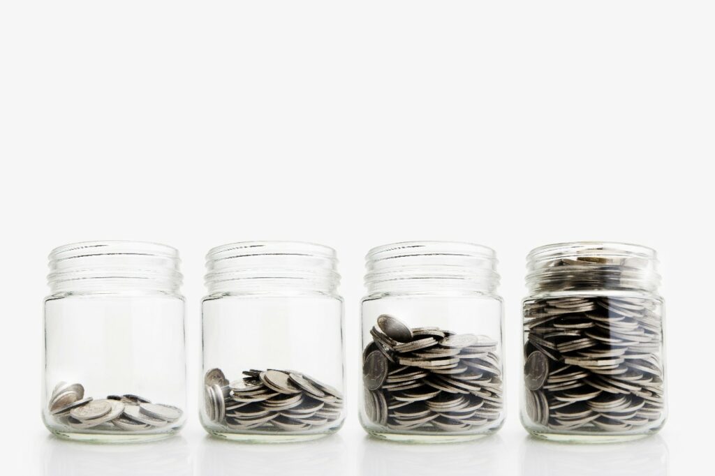 Four cans with various amounts of coins.