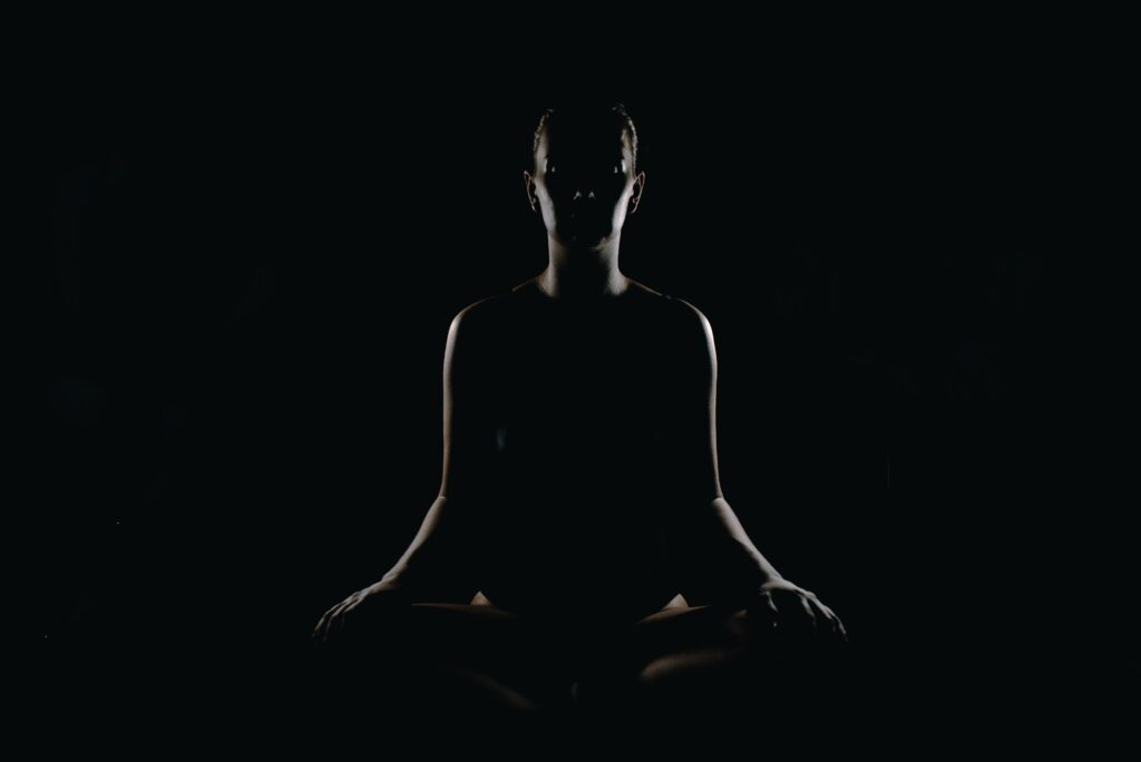 An image of a lady sitting in a yoga position