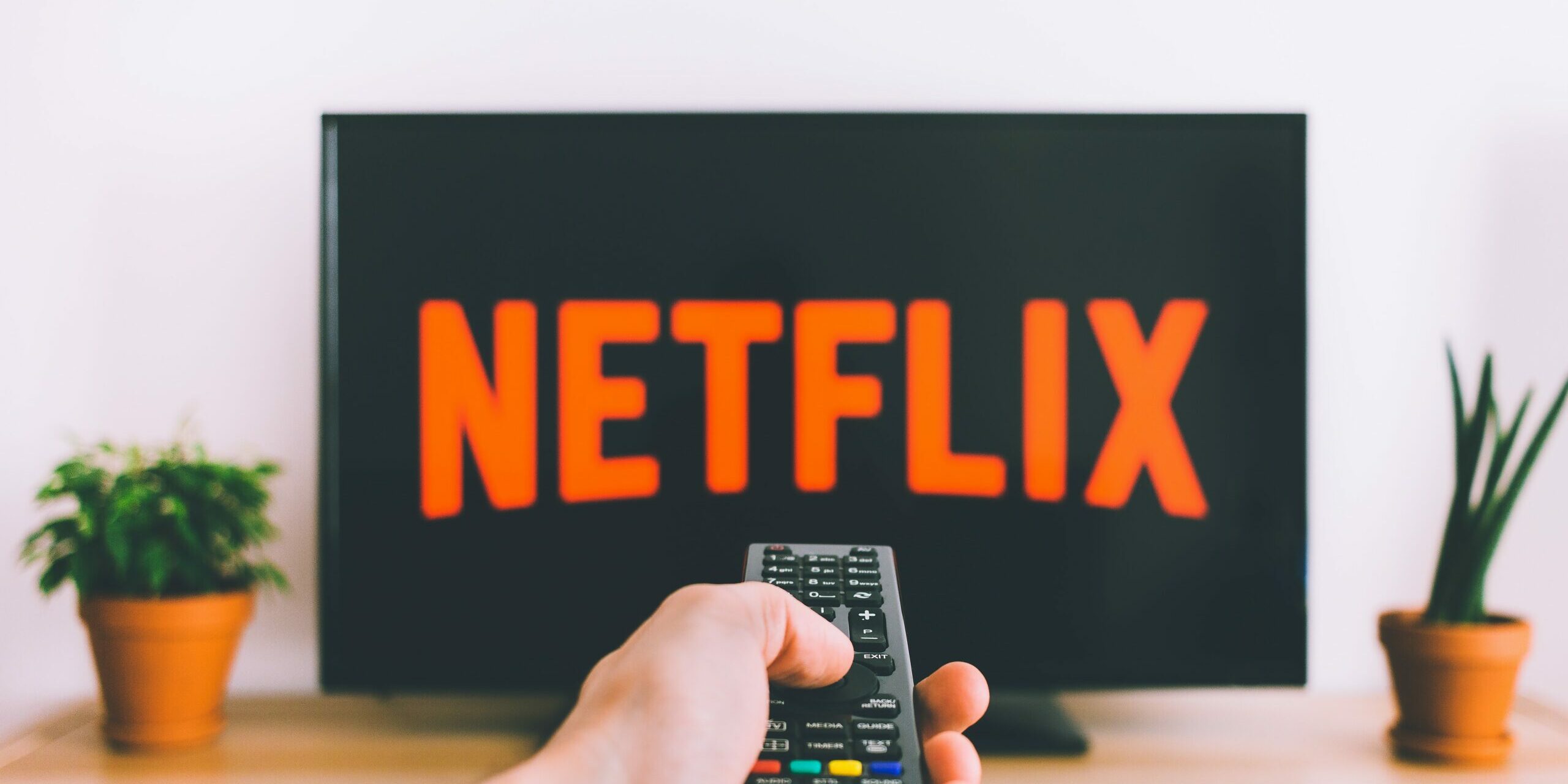 A person watching tv with a remote in their hand